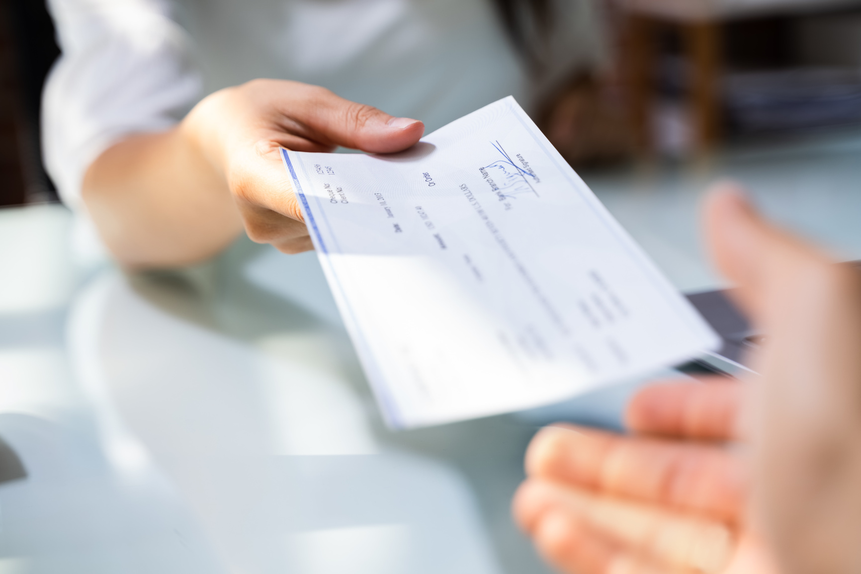 Hand Giving Payroll Compensation Paycheck